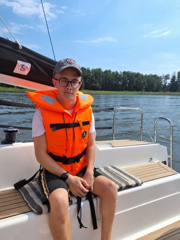 Sebastian w kamizelce ratunkowej na łódce